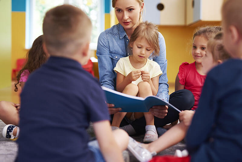 Erzieherin erklärt Kindern etwas